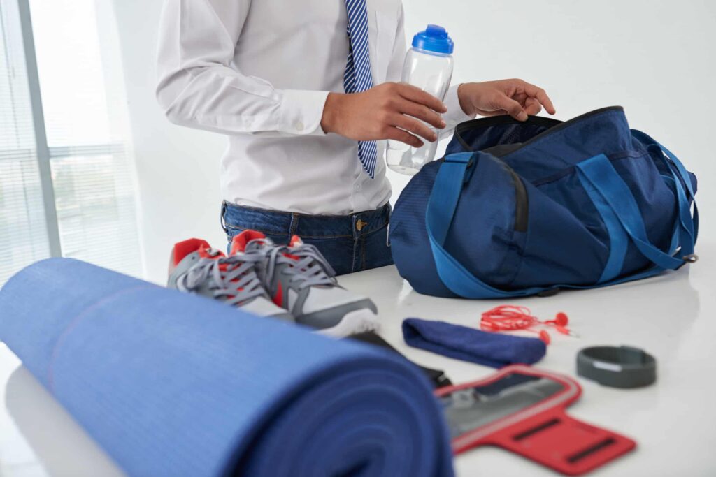 man pakt sporttas in met sport items